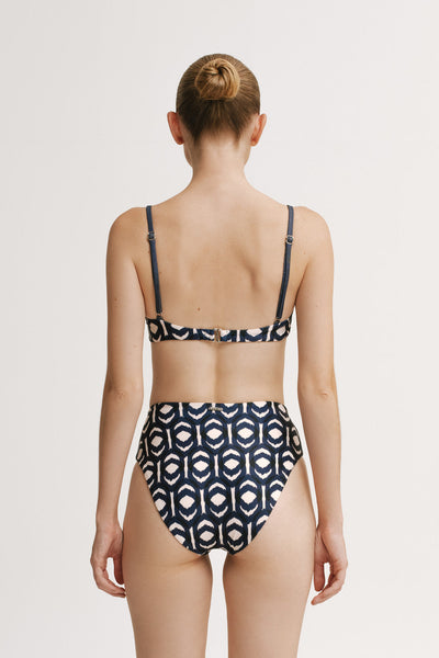 Back view of model wearing the Ruby Ikat high-waisted bikini bottom in navy ikat print