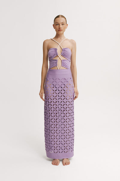 Model wearing a lavender dress with cut-out design on a white background