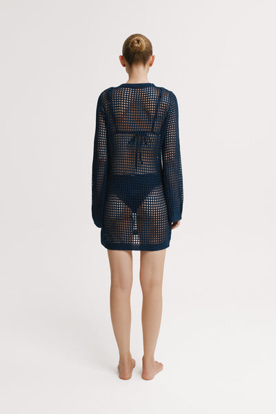Back view of navy open-knit mini dress with long sleeves.