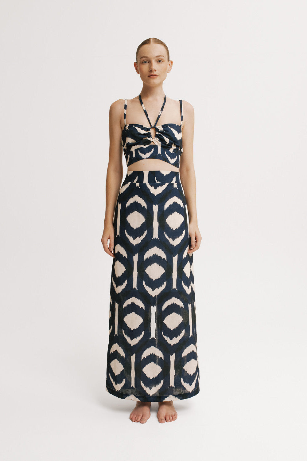 Halter crop top and maxi ikat skirt styled together in full-length studio shot.