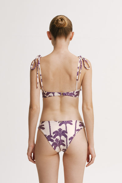 Woman wearing a patterned bikini set on a plain background