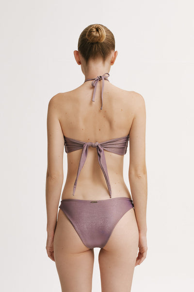 Woman wearing a purple bikini with a white background