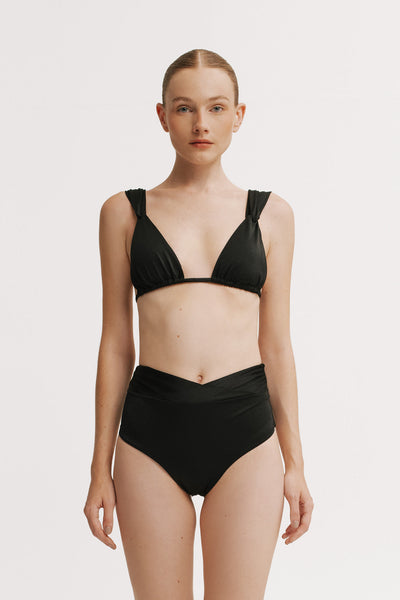 Front view of model wearing black bikini top with gathered straps