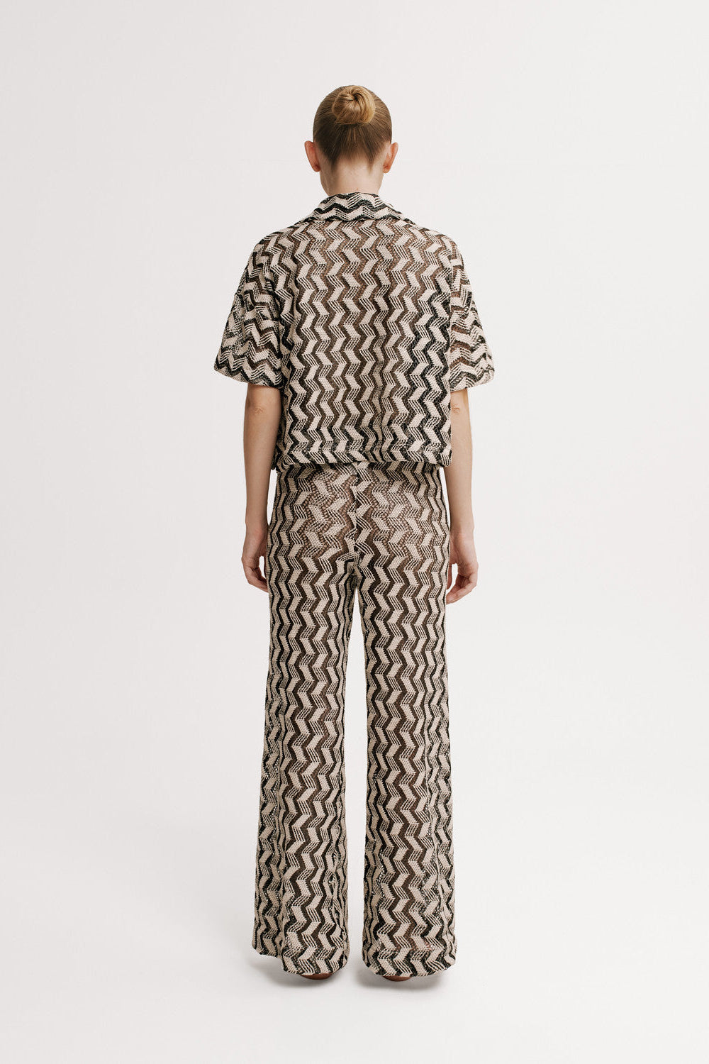 Person wearing a patterned outfit on a white background