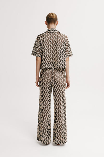 Person wearing a patterned outfit on a white background