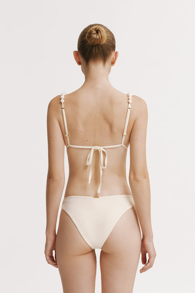 Woman wearing a beige bikini on a white background