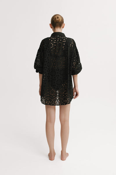 Person wearing a black sequin dress on a white background