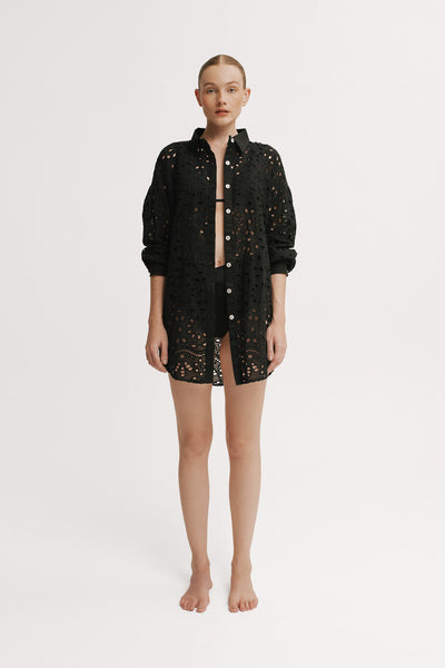 Woman wearing a black lace dress on a white background