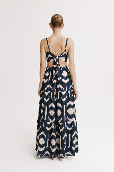 Woman wearing a patterned dress with cut-out design on a white background