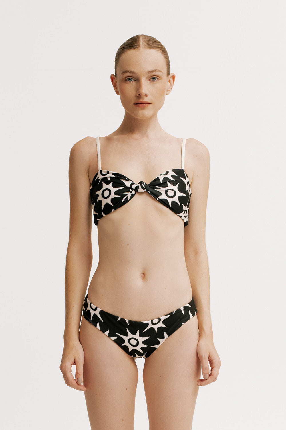 Woman wearing a black and white floral bikini on a white background