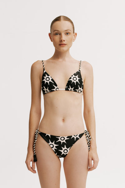 Woman wearing a black and white patterned bikini on a plain background