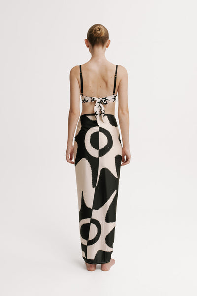 Woman wearing a black and white patterned dress on a plain background