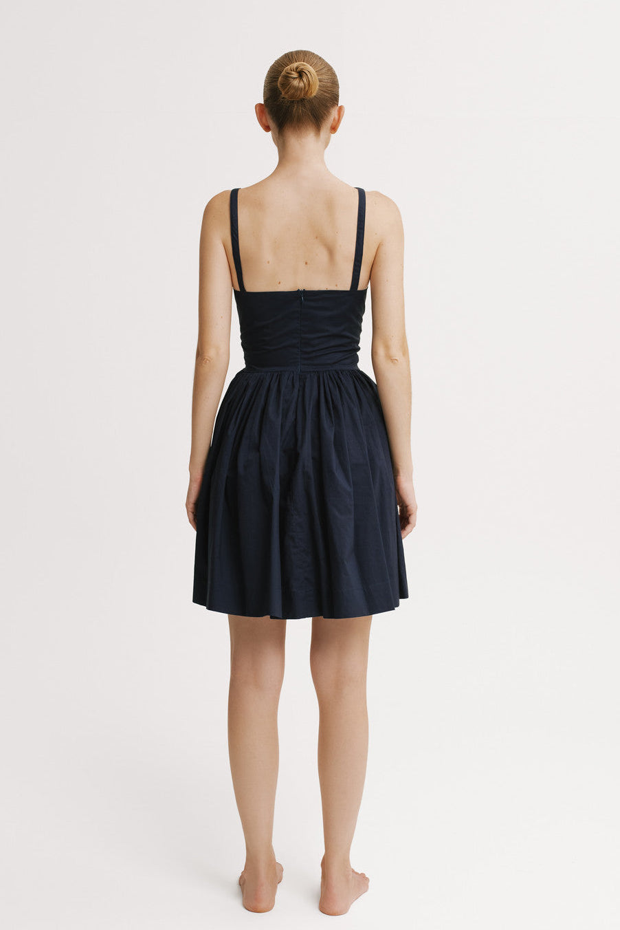 Back view showing fitted bodice and flowy mini skirt.