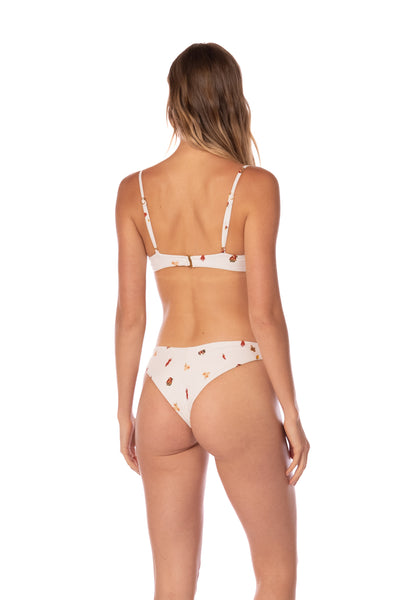 Woman wearing a white bikini with floral patterns on a white background