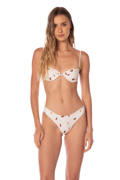 Woman wearing a white bikini with red heart patterns on a white background
