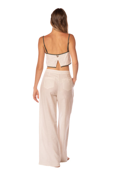 Woman wearing a beige top and wide-leg pants on a white background