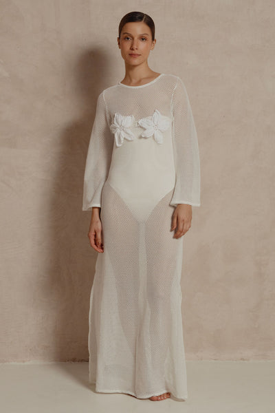 Model wearing white mesh Coral Flora maxi dress with floral appliqués on bust.