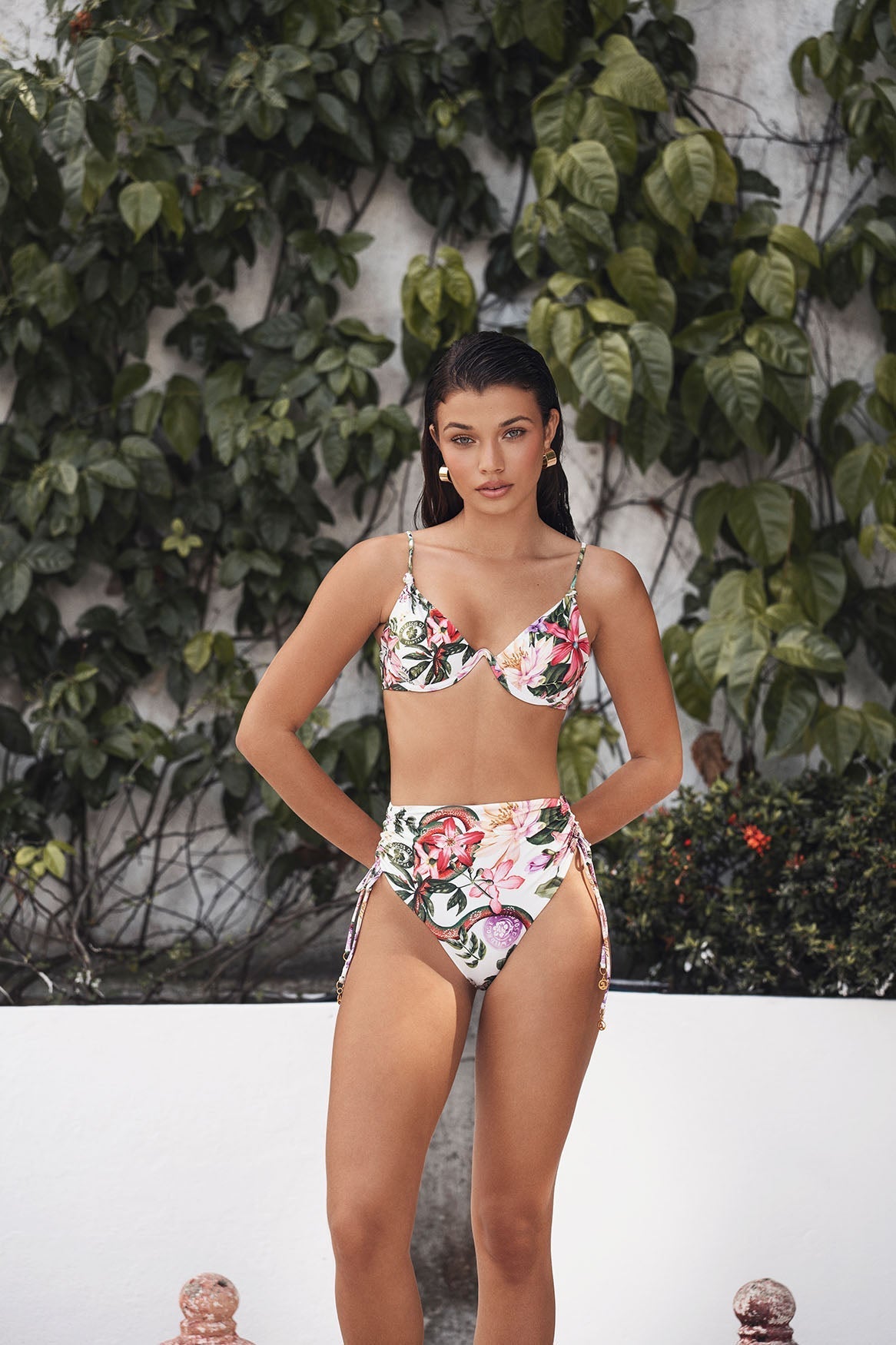 Woman wearing a floral bikini set against a leafy green background