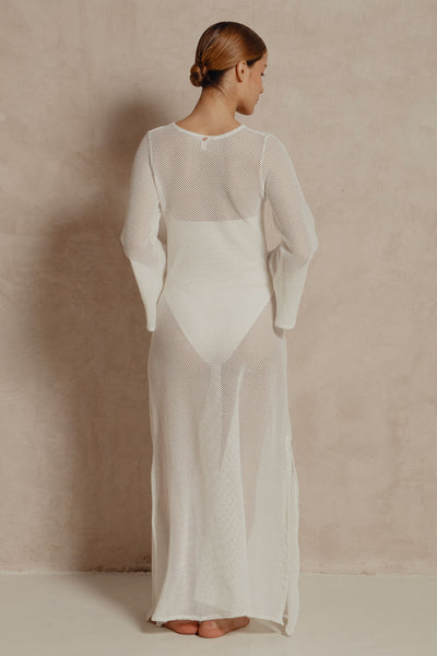 Back view of white long-sleeve mesh maxi dress showing sheer open-weave fabric.