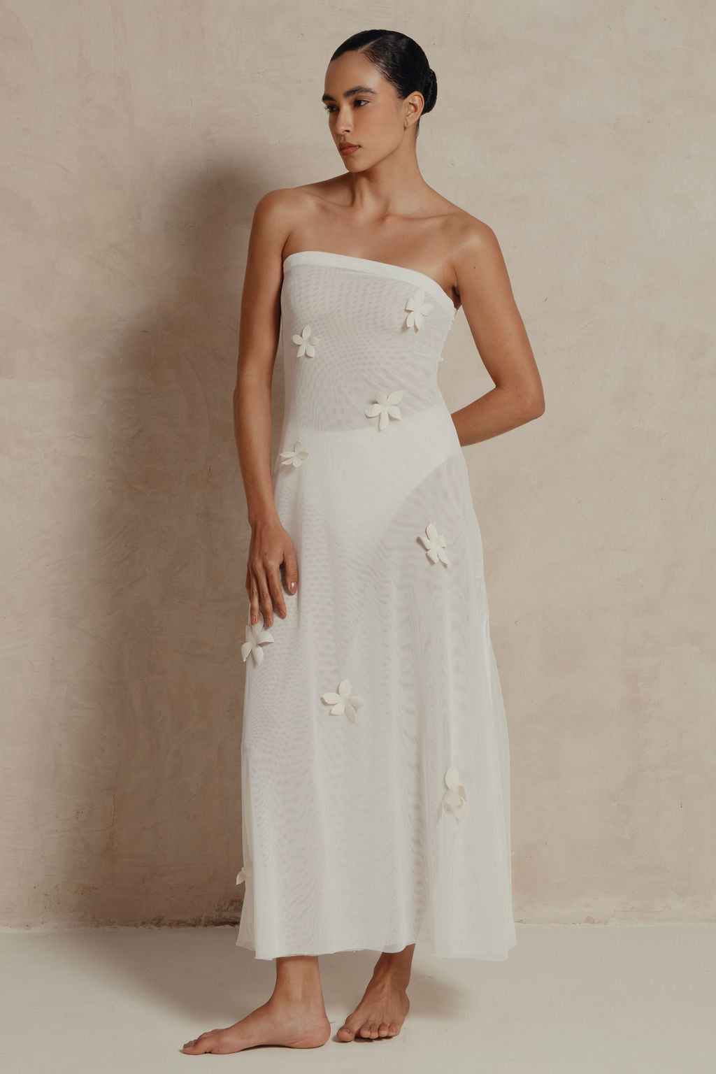 Model wearing strapless white mesh maxi dress with 3D floral appliqués, front view.