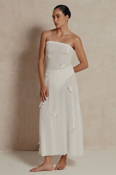 Model wearing strapless white mesh maxi dress with 3D floral appliqués, front view.