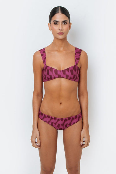 Woman wearing a purple bikini with a pattern on a white background