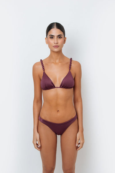 Woman wearing a maroon bikini set against a white background